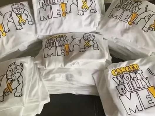 Cancer awareness artwork with yellow ribbons stitched on white garments